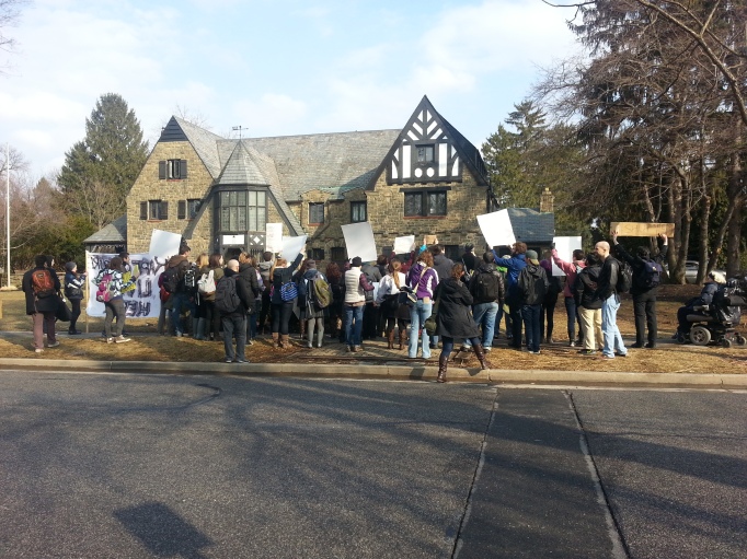 Picture of protesters shouting "Shame on You" in front of the Kappa Delta Rho House in State College, PA