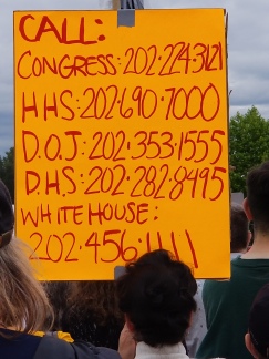 Sign listing the DC phone numbers for Congress (202-224-3121), Health and Human Services (202-690-7000), Department of Justice (202-353-1555), Department of Homeland Security (202-282-8995), and the White House (202-456-1111)